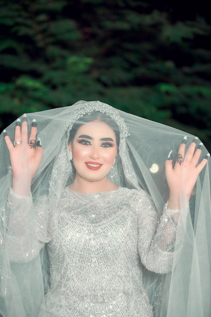 A woman in a wedding dress holding her veil